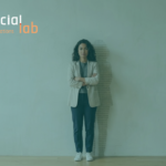 A portrait of a confident woman standing against a plain wall with a shadow composed of binary code patterns, symbolizing women's empowerment and leadership in technology and AI development at SocialLab.